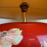large vintage ceramic lamp with flower decorations on a red background circa 1980