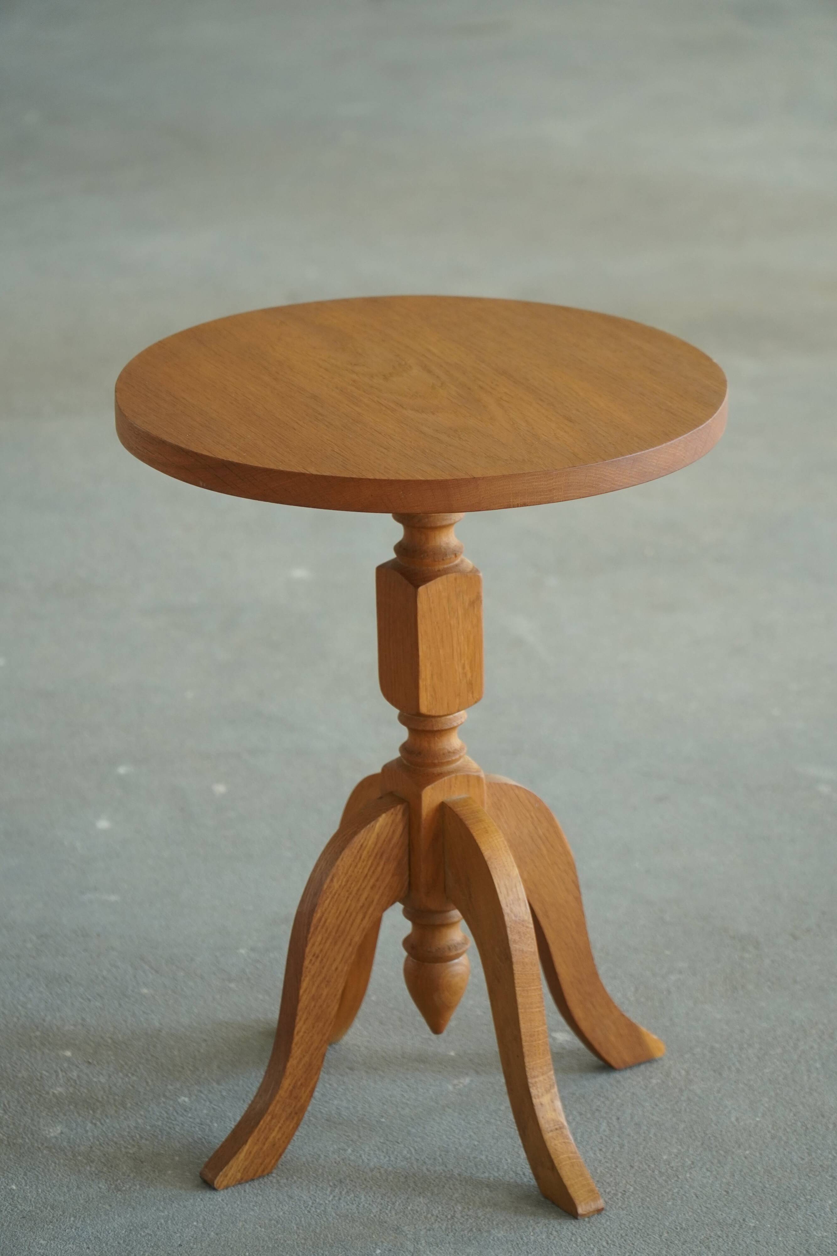 Pair of Scandinavian oak side tables with central legs and sculptural curved feet, 1960s.