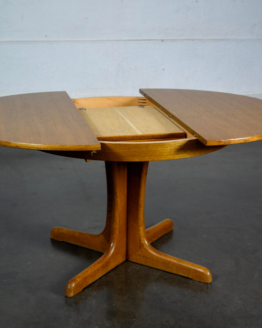 Round teak table with an extension.