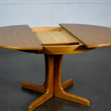 Round teak table with an extension.