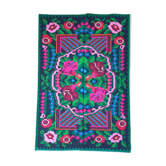 Handwoven colorful Romanian carpet, green and black background with gorgeous colorful flowers