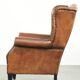 Sheepskin wingback armchair finished with black piping and a correct seat