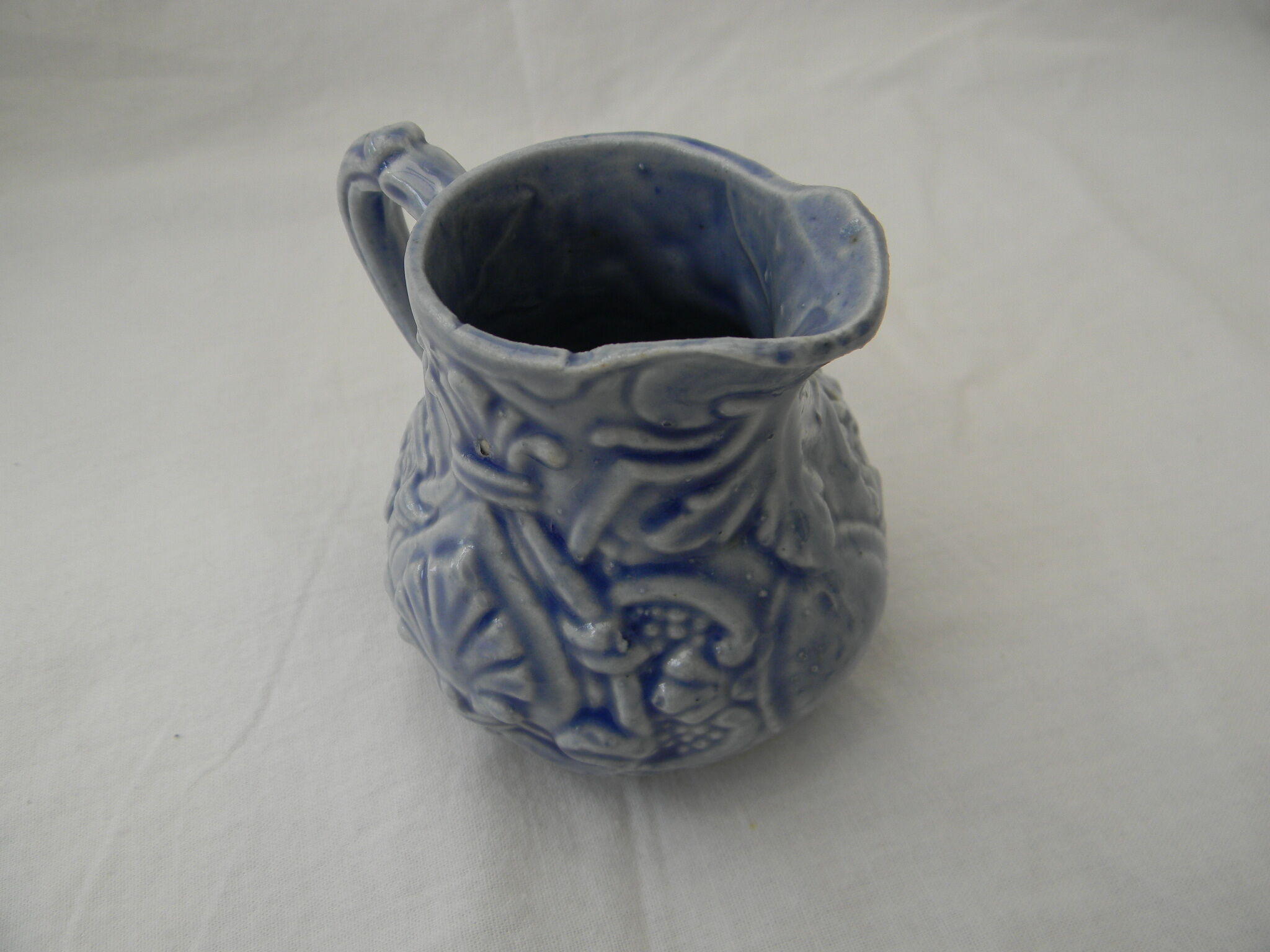 Petit pot à lait bleu en barbotine.