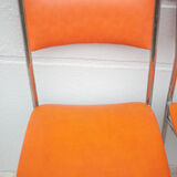 Pair of chrome metal chair and orange skai