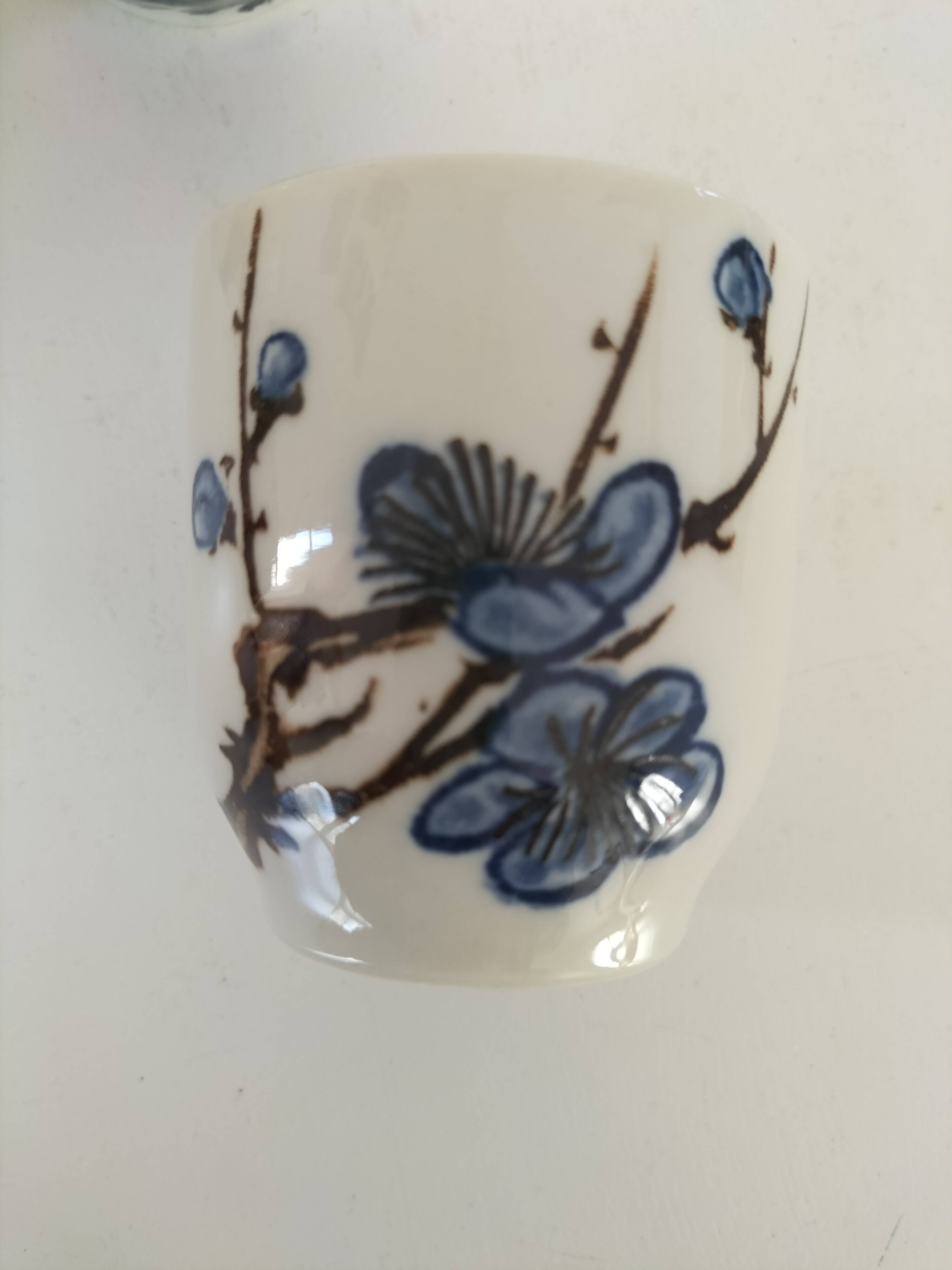 Set of three hand-painted porcelain cups with floral patterns.