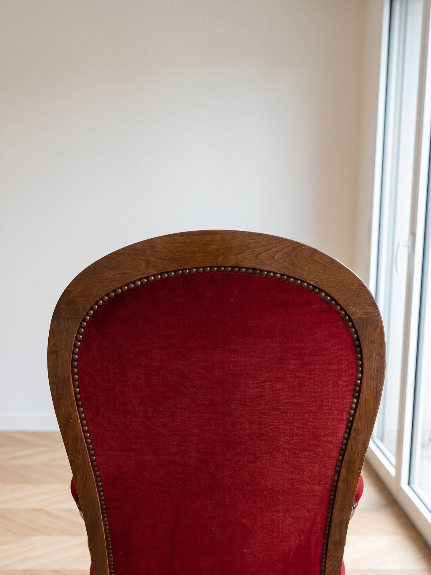 Antique armchair in carved wood and red fabric.