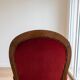 Antique armchair in carved wood and red fabric.