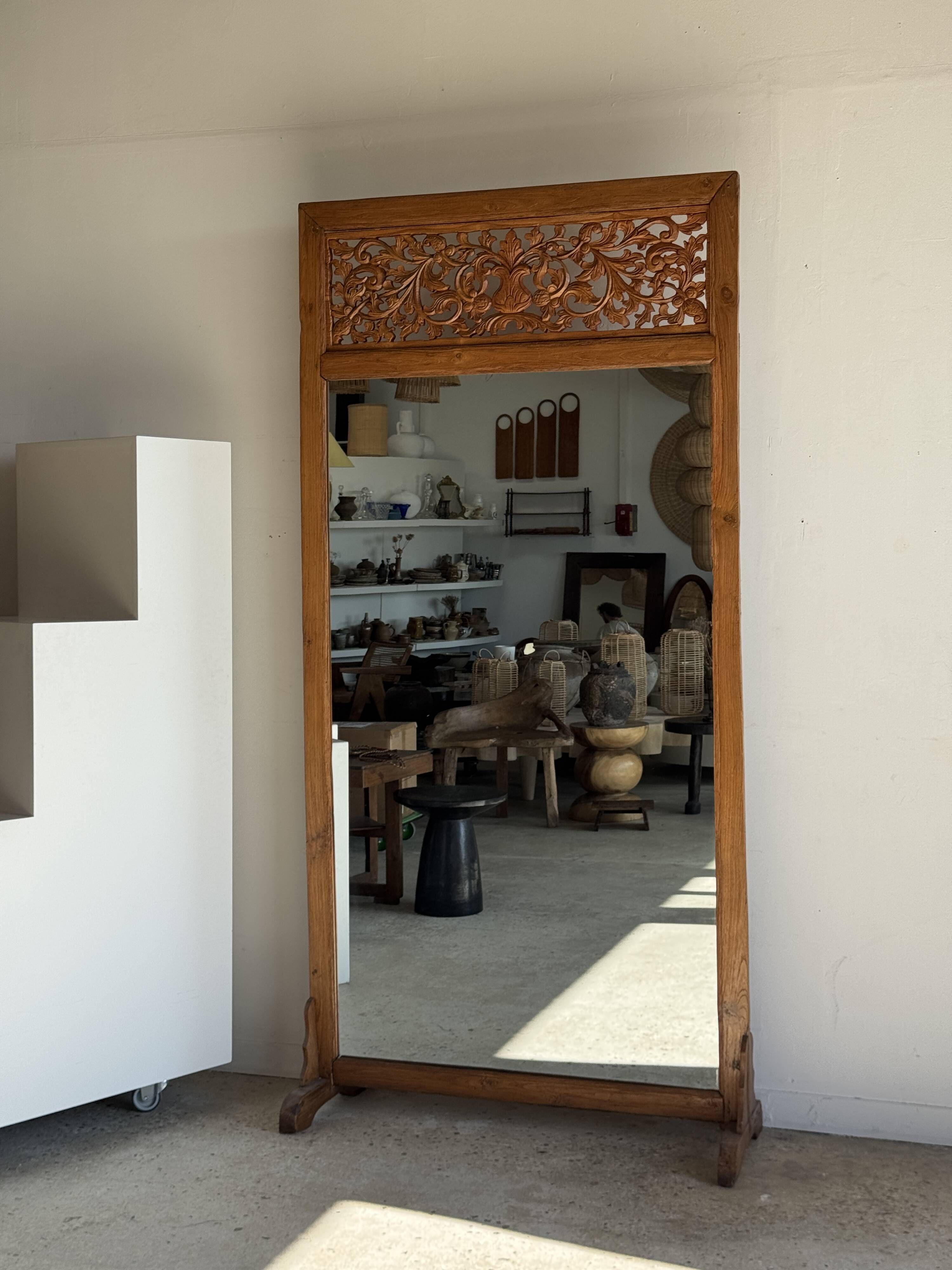 Very large freestanding teak mirror with an openwork carved pediment, Indonesia.