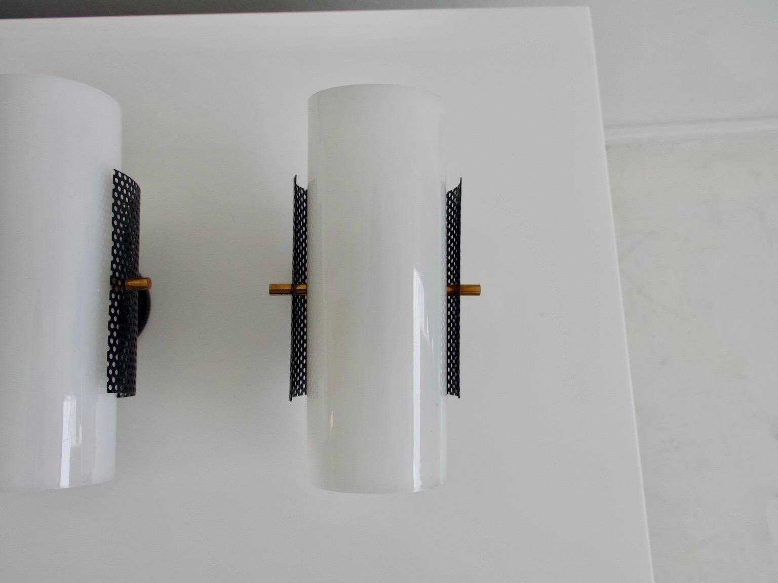 Set of four wall lights in white plexiglass and perforated black metal.