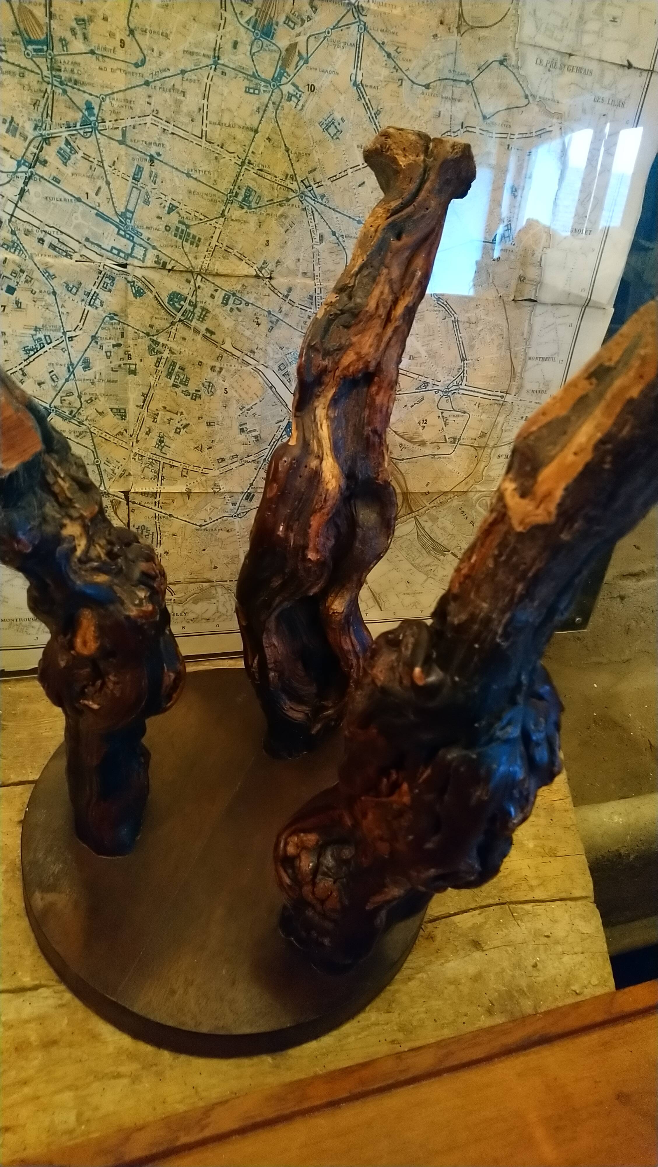 Brutalist tripod stool made from vine stumps.