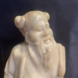 Soapstone sculpture on obsidian base of a Buddhist.