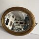 Antique oval mirror in gilded wood, bevelled mercury glass, 19th century.