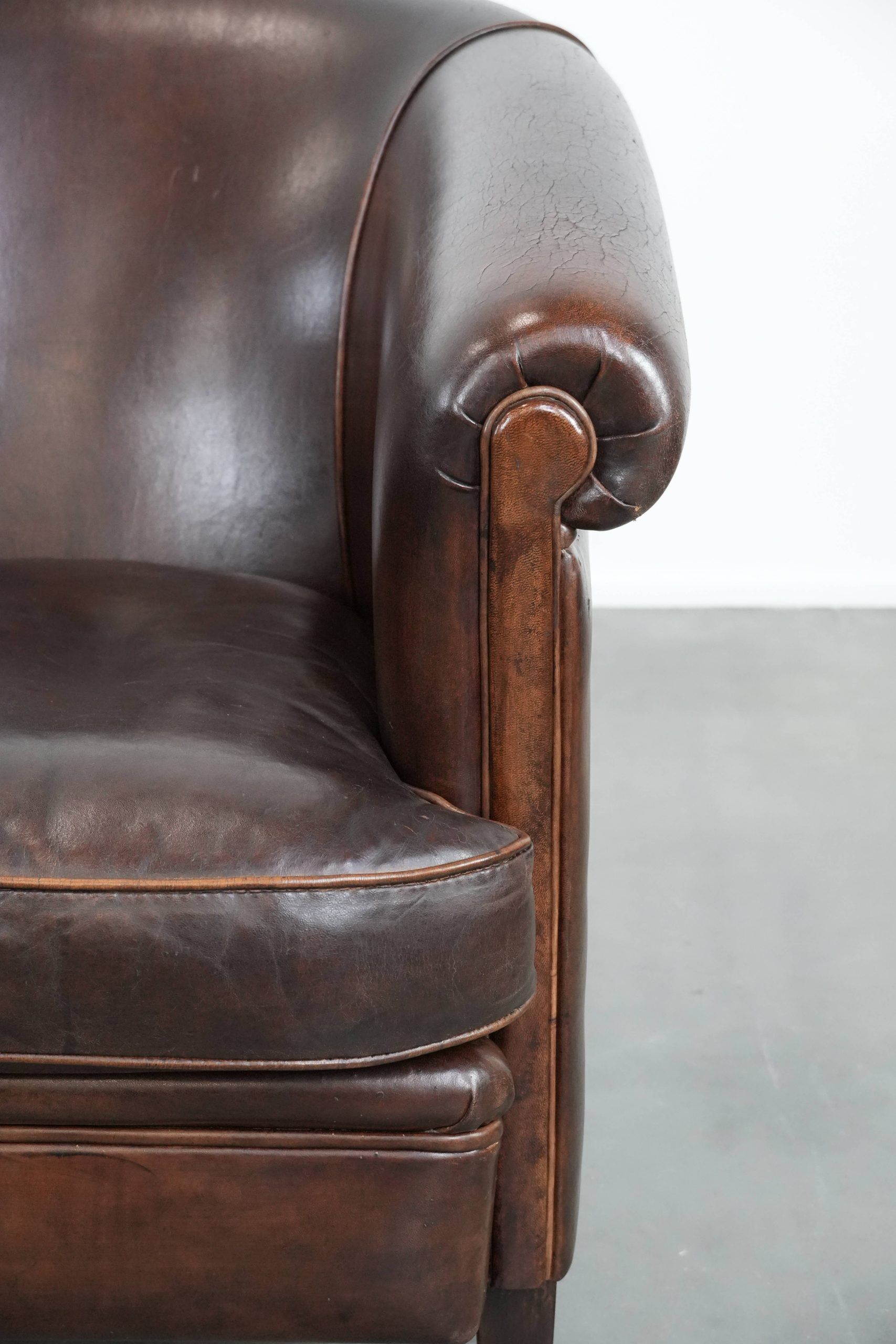 Dark brown vintage club armchair in English style made of sheepskin leather