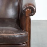 Dark brown vintage club armchair in English style made of sheepskin leather