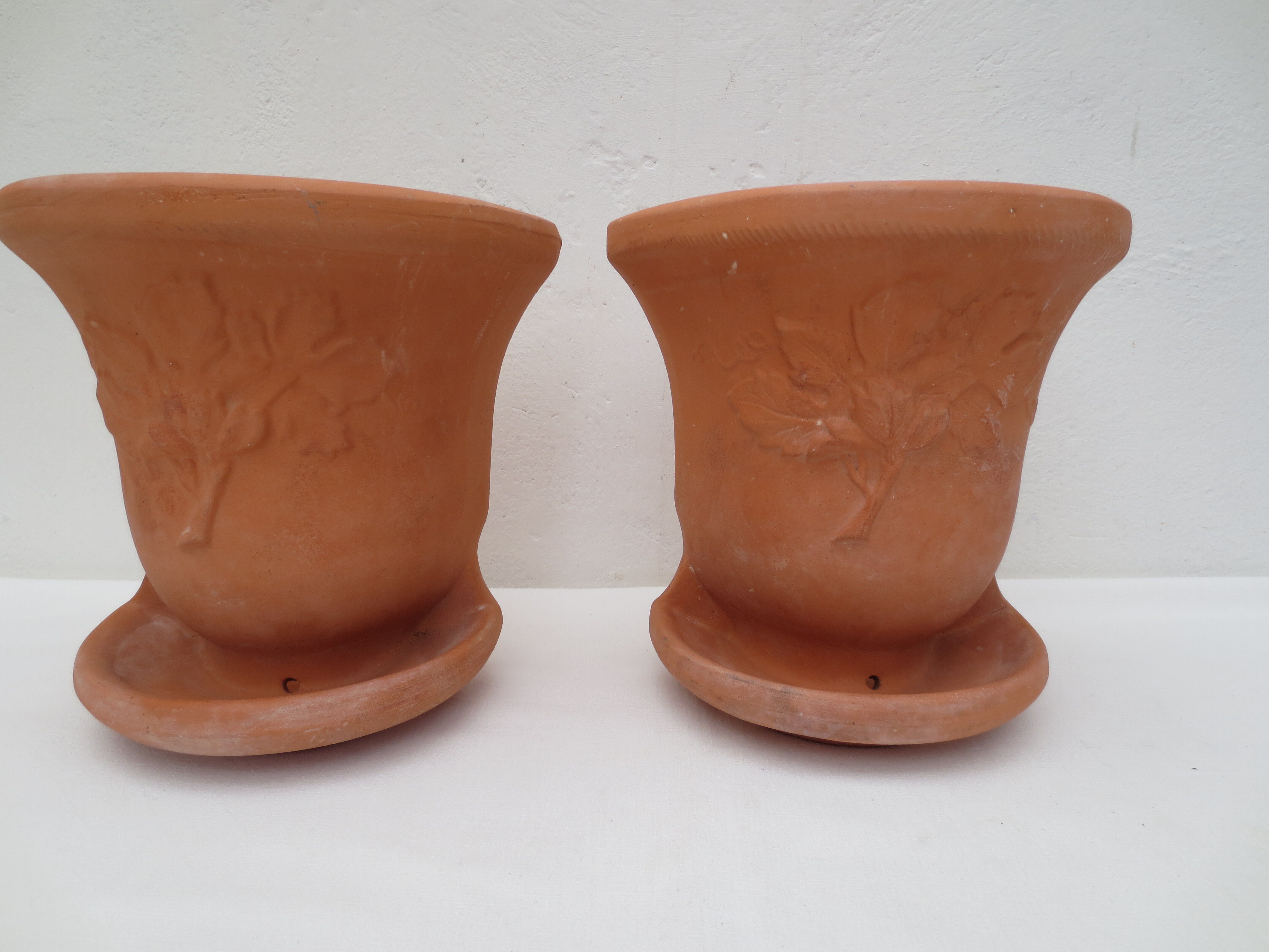 Duo of decorated terracotta wall flowerpots