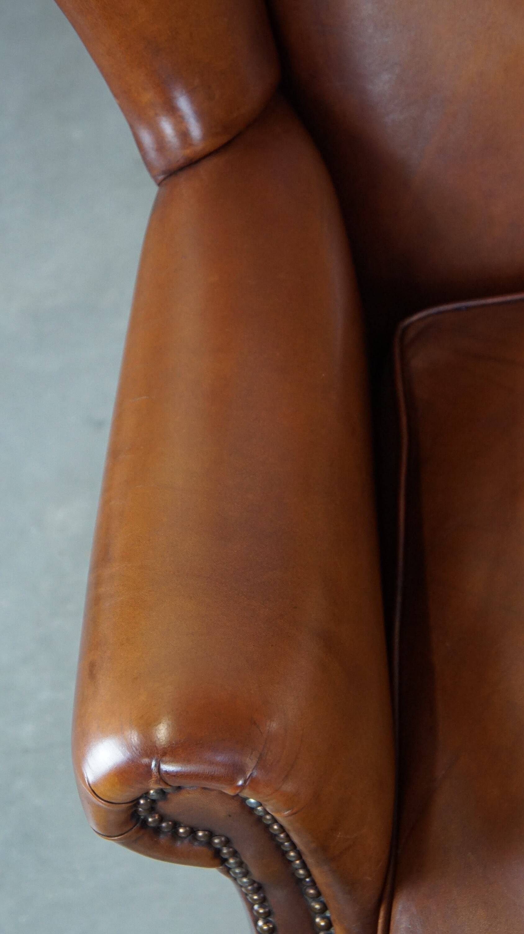 Fauteuil à oreilles en cuir de vachette cognac