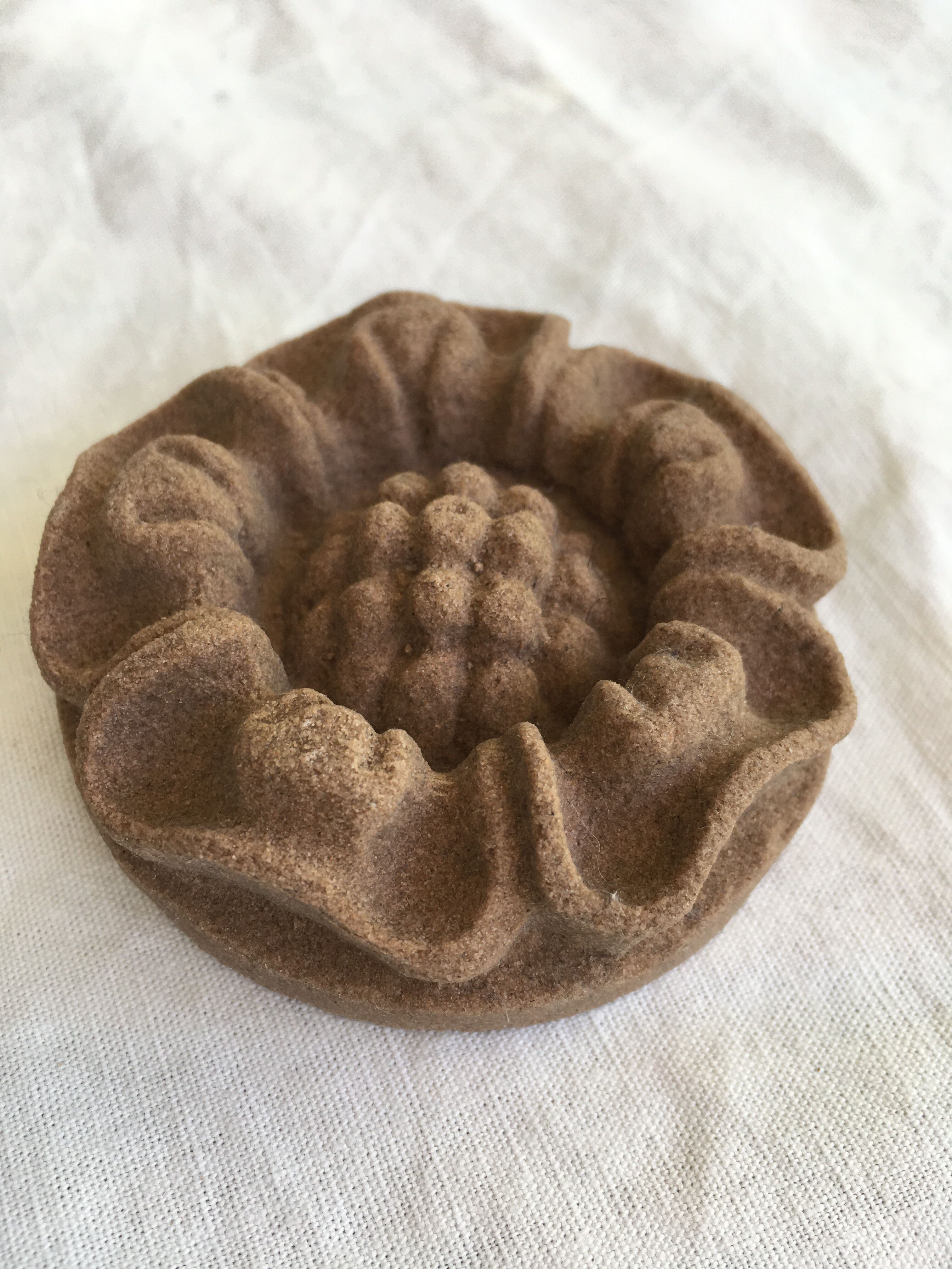 Pink sandstone paperweight in the shape of a rosette