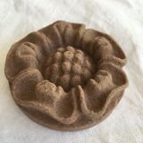 Pink sandstone paperweight in the shape of a rosette