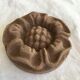 Pink sandstone paperweight in the shape of a rosette