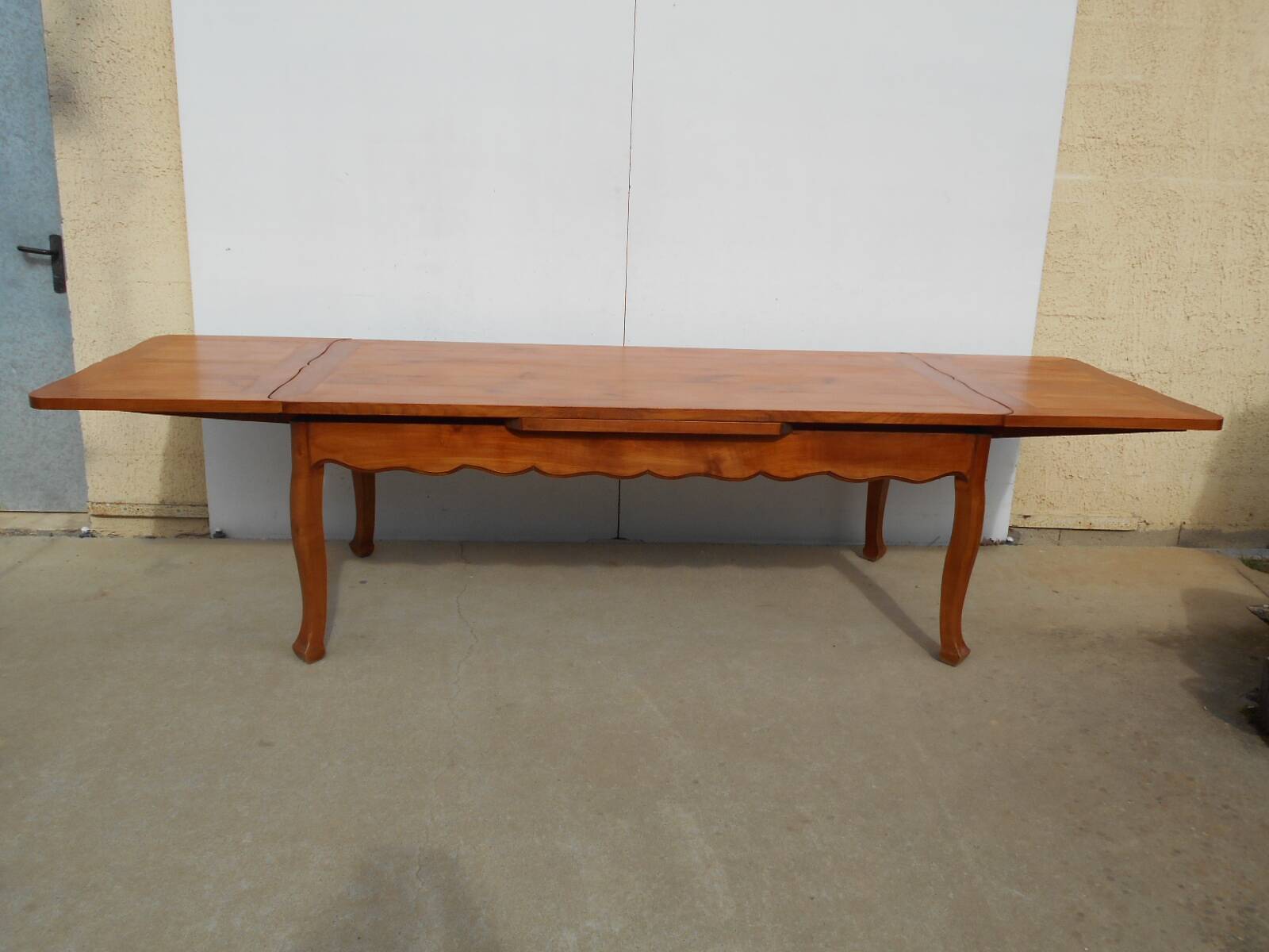 Large solid wood table with integrated extensions.