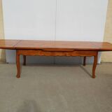 Large solid wood table with integrated extensions.