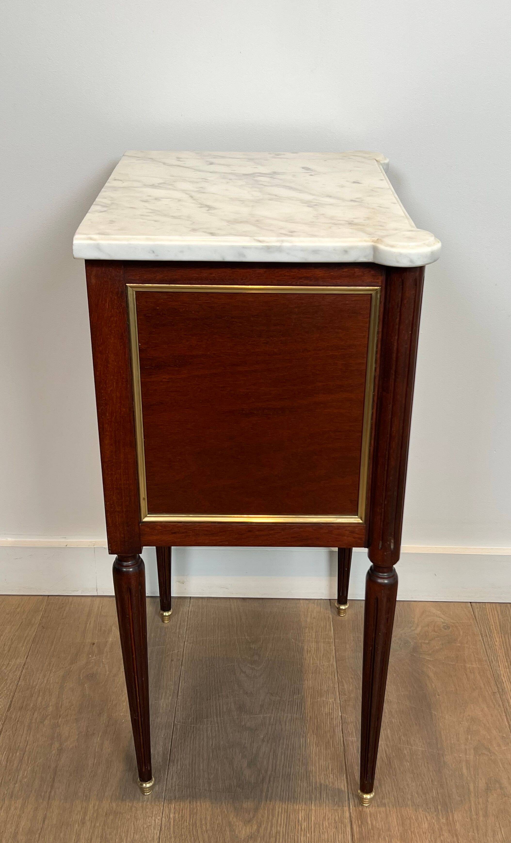 Pair of mahogany and brass side tables or bedside tables with Carrara marble tops.