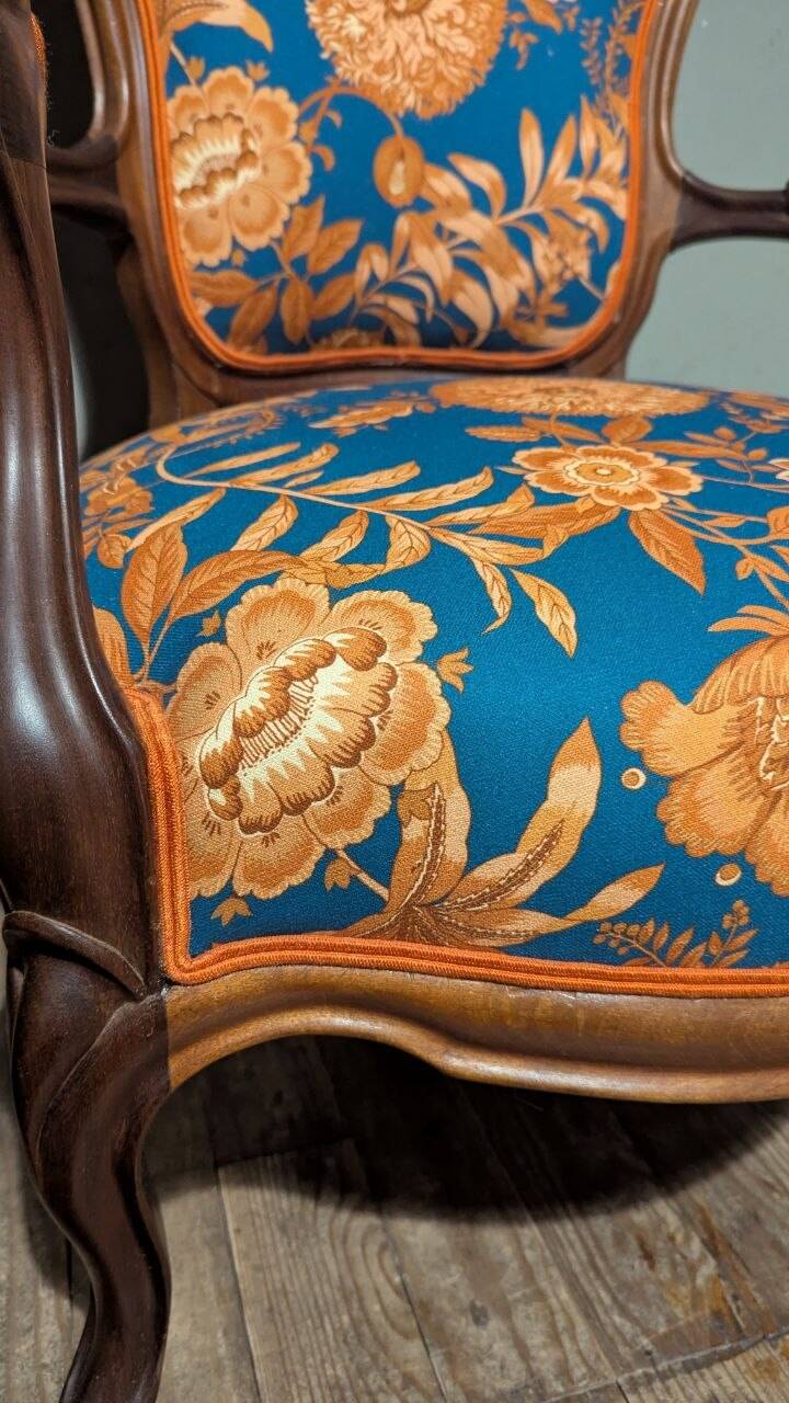 Restored Louis-Philippe cabriolet armchair, blue and orange floral fabric.