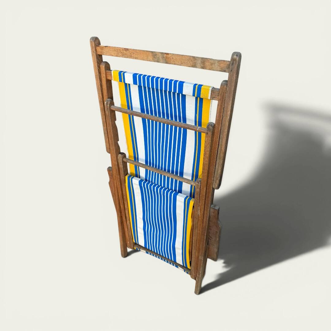 Vintage deck chair with blue and yellow striped fabric, original patina.