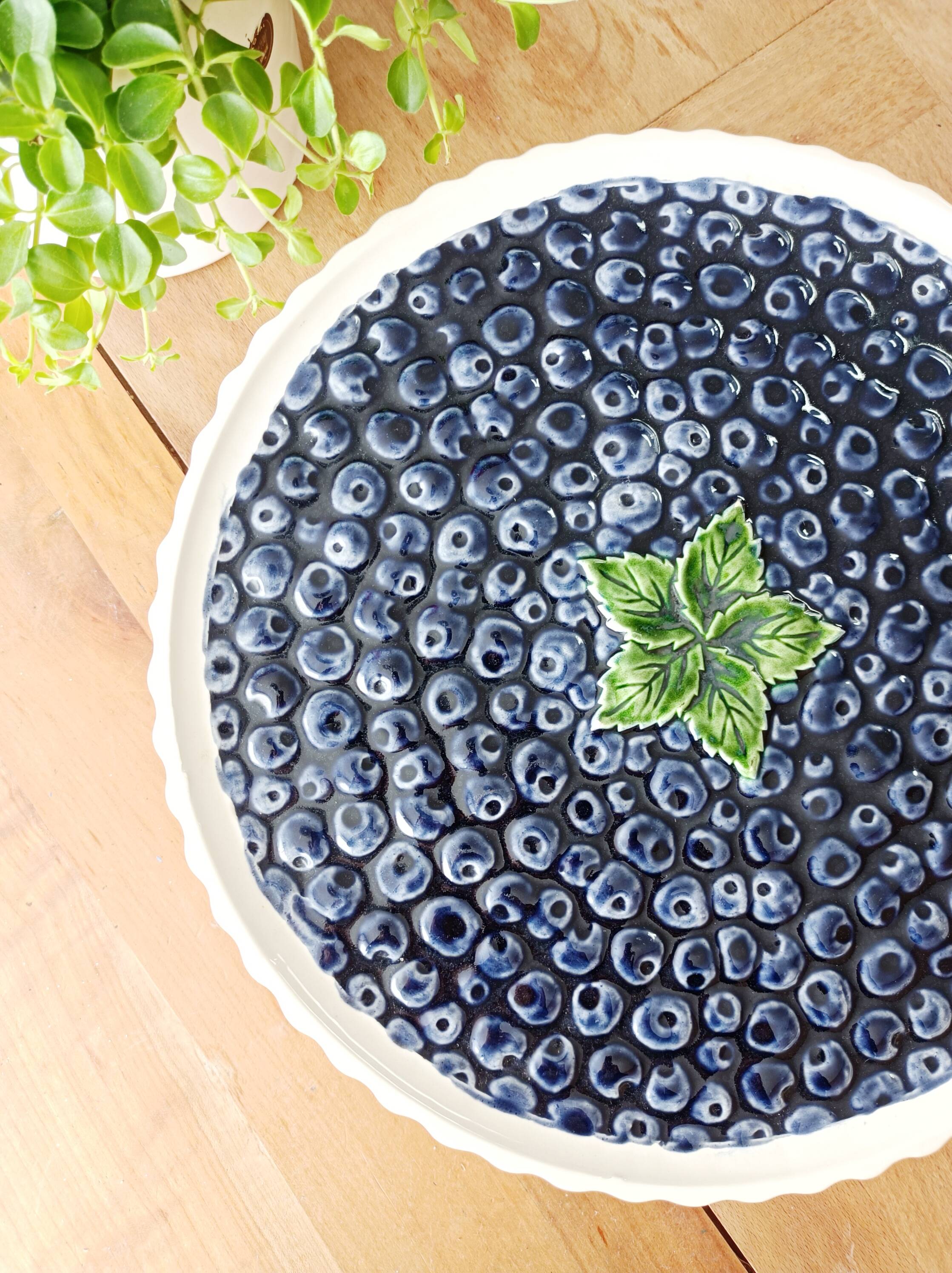 Pie dish on foot, in slip with blackberry decoration