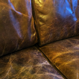 Patinated brown stitched leather 2 seater sofa with brass studs