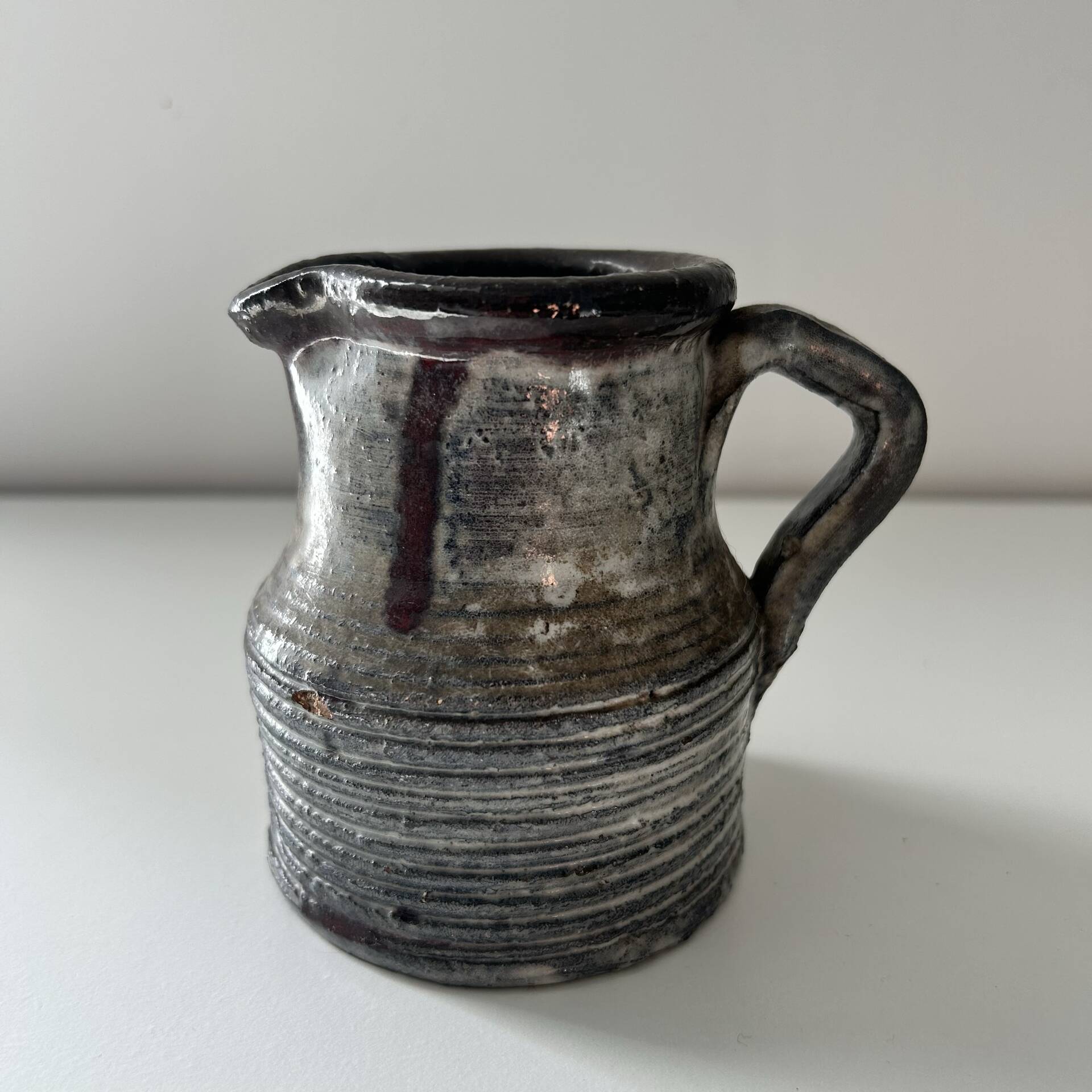Patinated pitcher signed