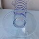 Glass vase on a pedestal with a blue trim.