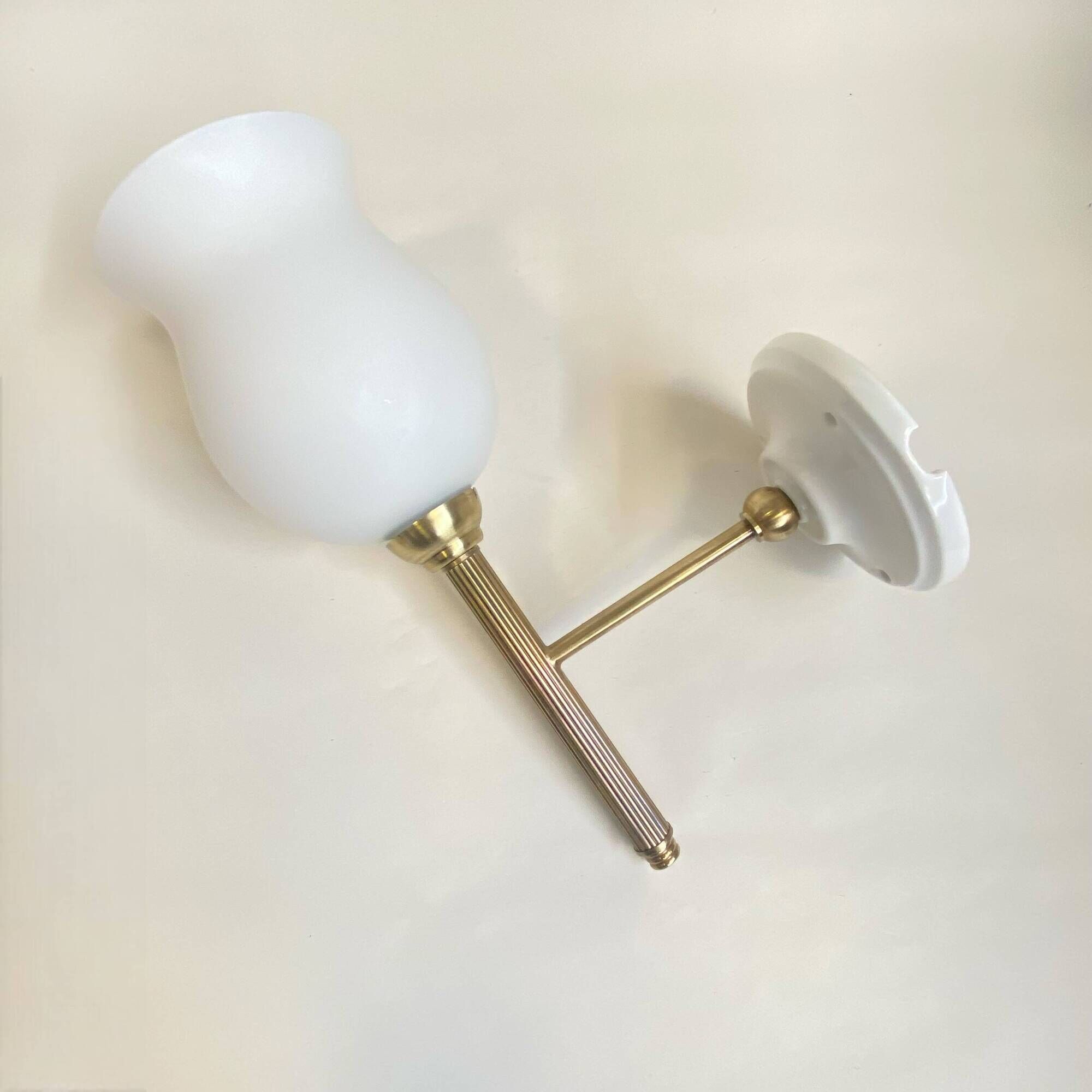Pair of brass torch wall lights with white opal glass and porcelain