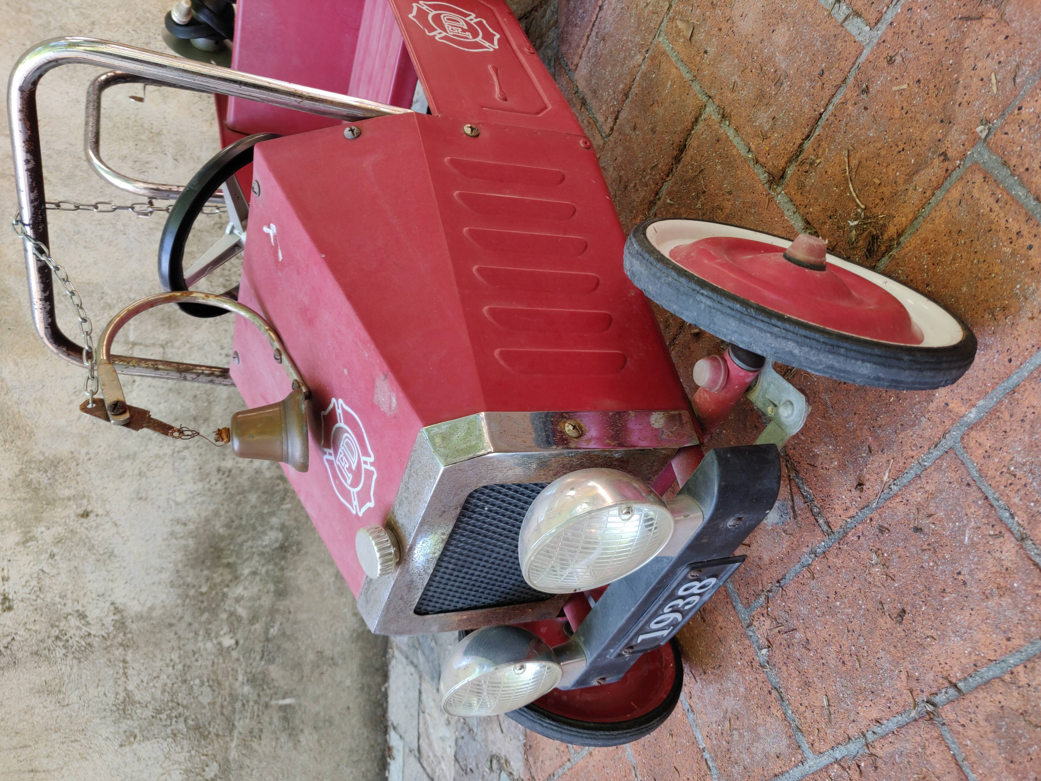 Old pedal car in tole fire truck