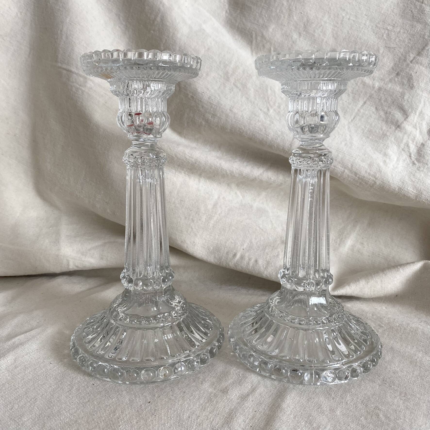 Column candle holders in moulded glass made in France.