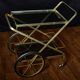 Vintage rolling trolley in gold metal & smoked glass – Retro elegance as