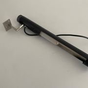 Minimalist black metal wall light with a cylindrical design, 1960s, Germany.