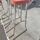 Pair of aluminum bar stools with orange and black seats