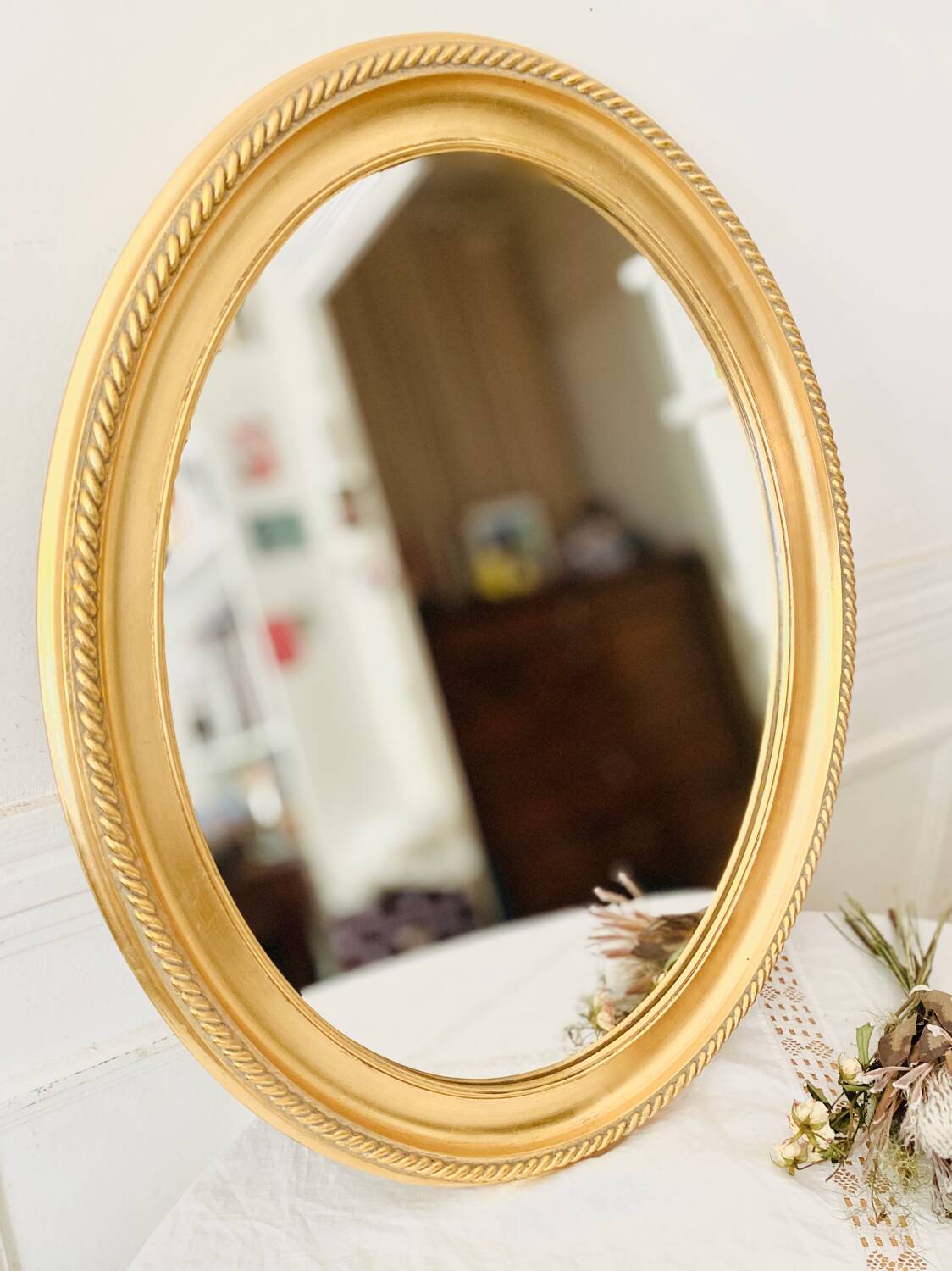 Oval wall mirror in gilded wood