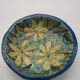 Hollow cut in blue enamelled sandstone decorated with yellow flowers