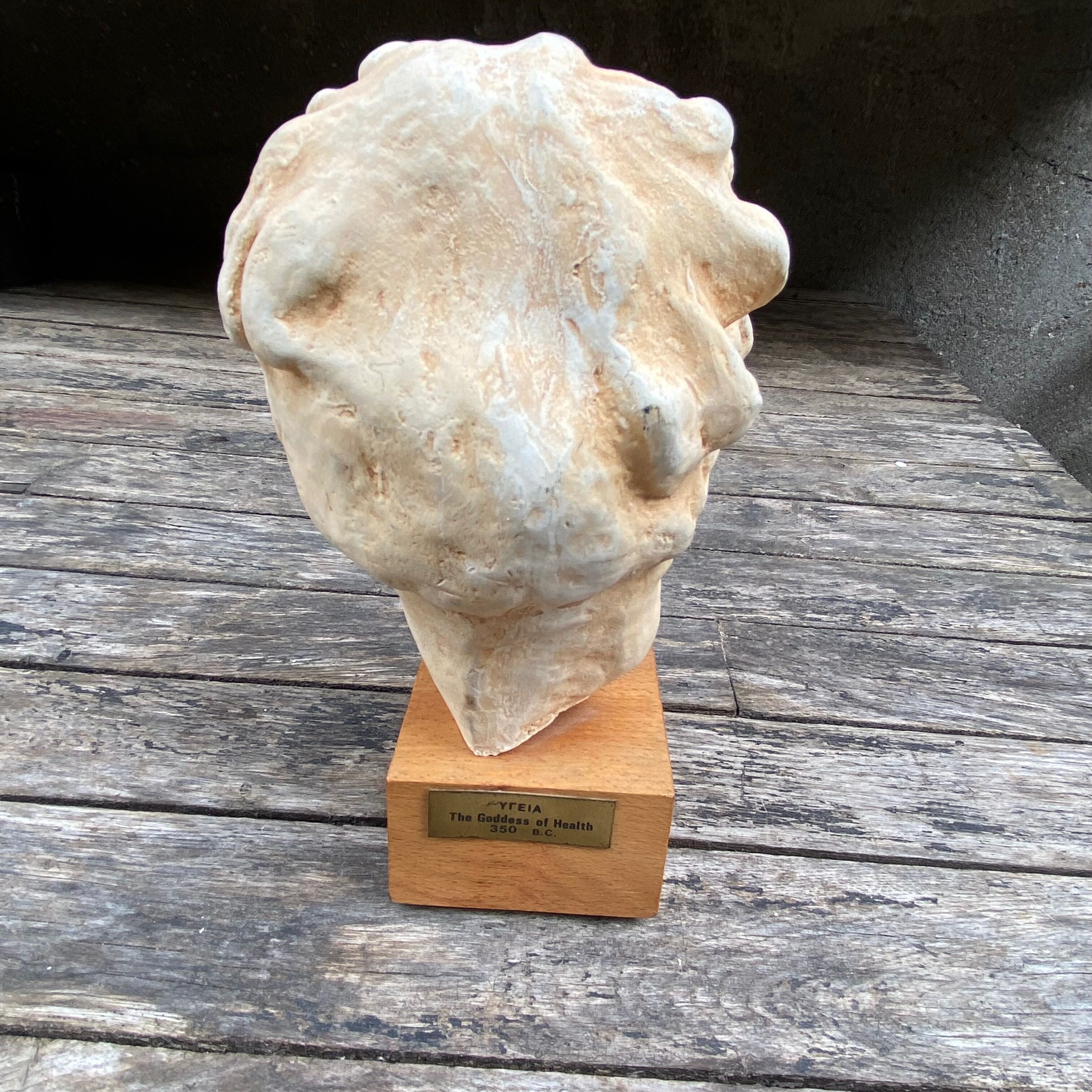 Plaster head of an ancient goddess on its wooden base