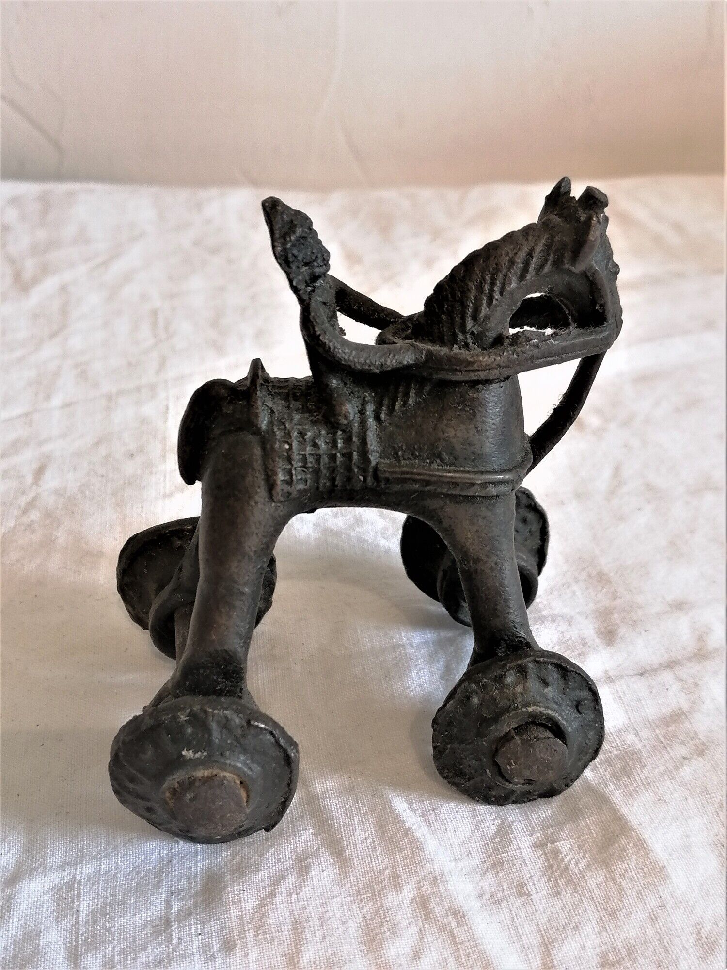Old child's toy. Horse with bronze wheels. Ethnic object.