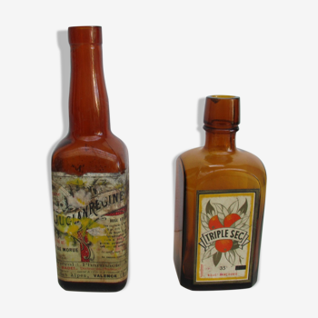 2 bouteilles en verre ambré avec leurs anciennes étiquettes