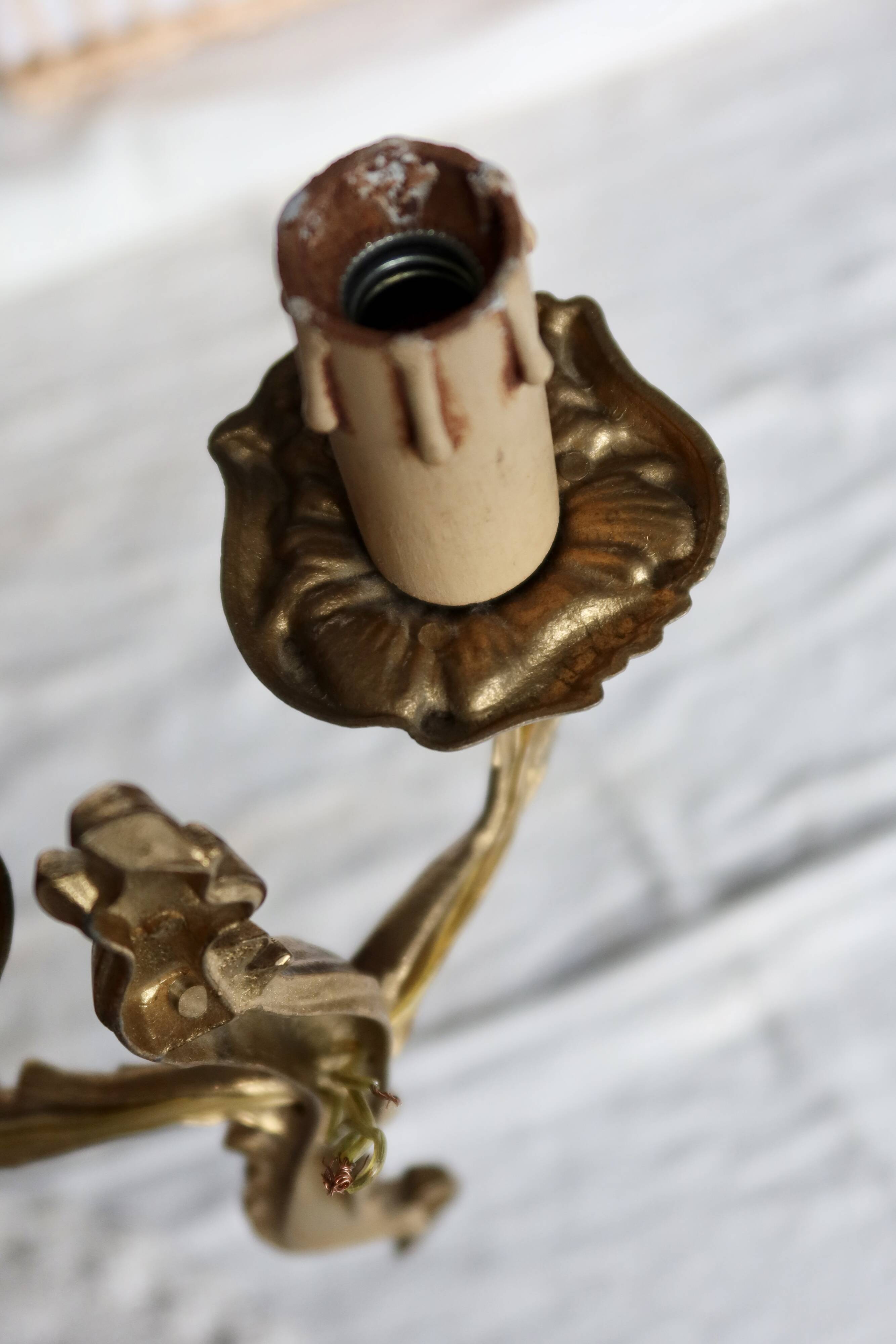 Vintage wall sconce in gold metal with two arms in classic style.
