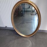 Large and elegant oval gilded mirror with its beveled glass