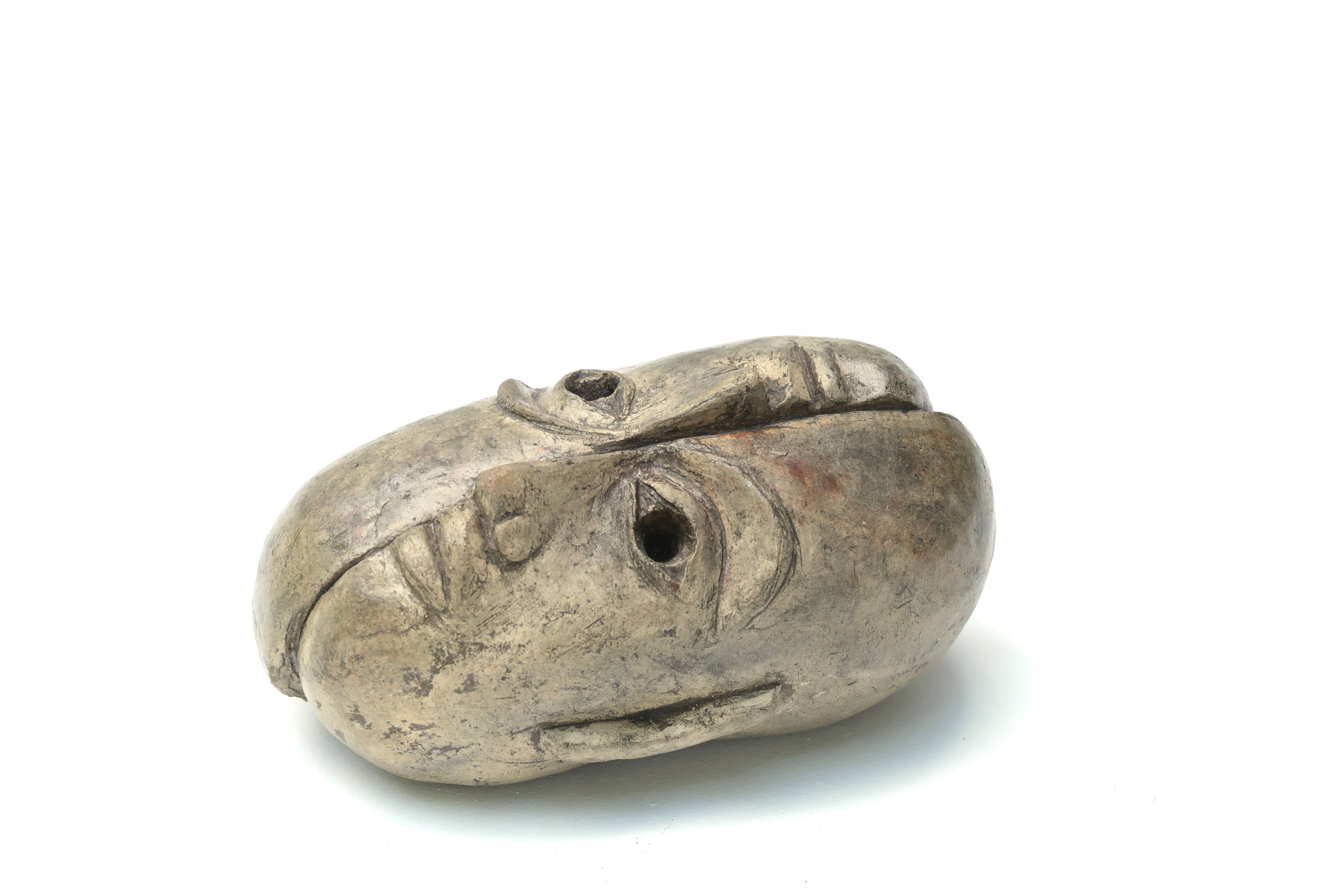Patinated plaster sculpture paper press: Inverted faces