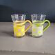 Pair of glass teacups with plastic handles