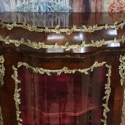 Curved display cabinet in Louis XV style with precious wood marquetry and gilded bronze.