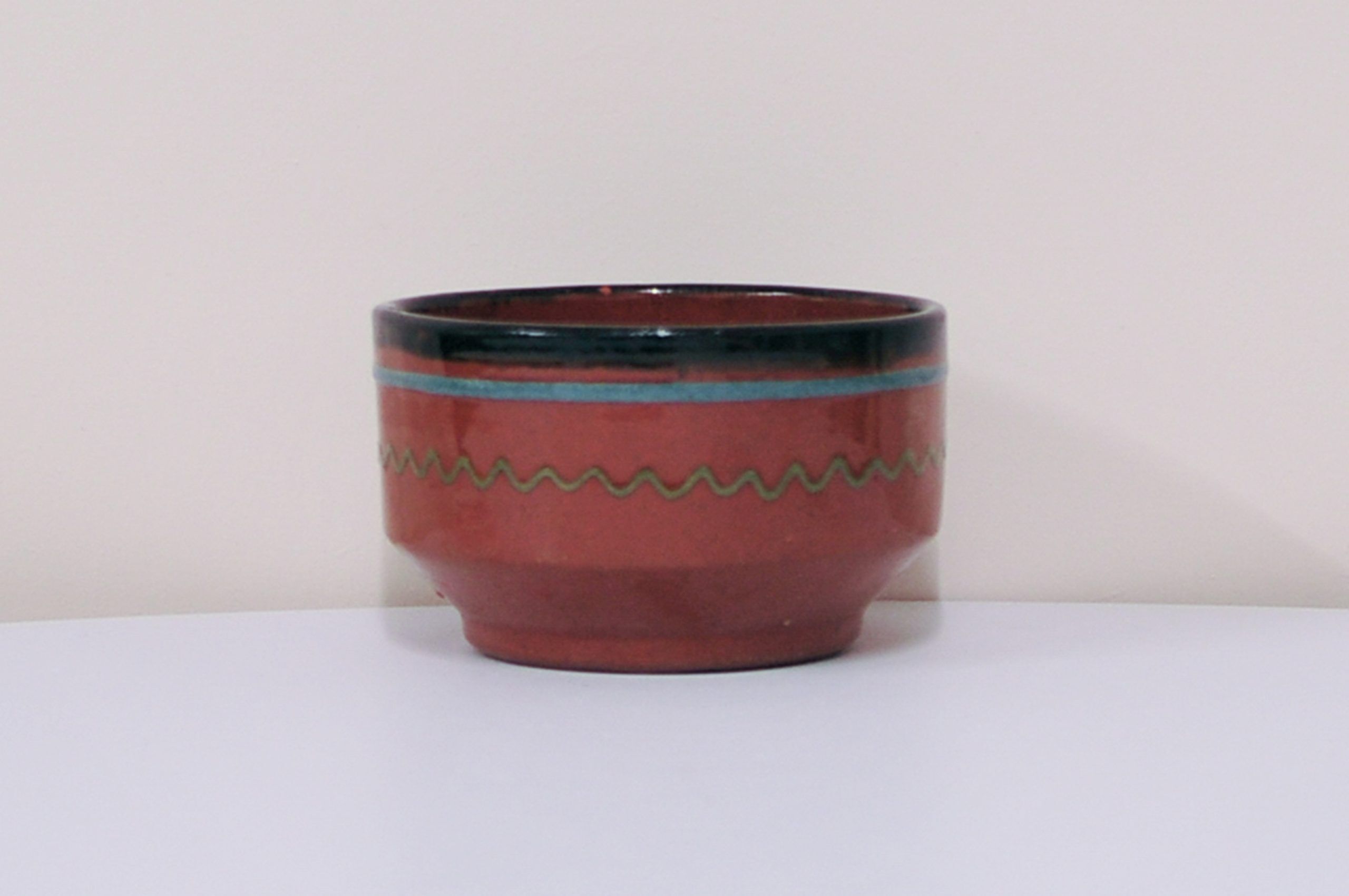 Brown bowl with a green and blue design