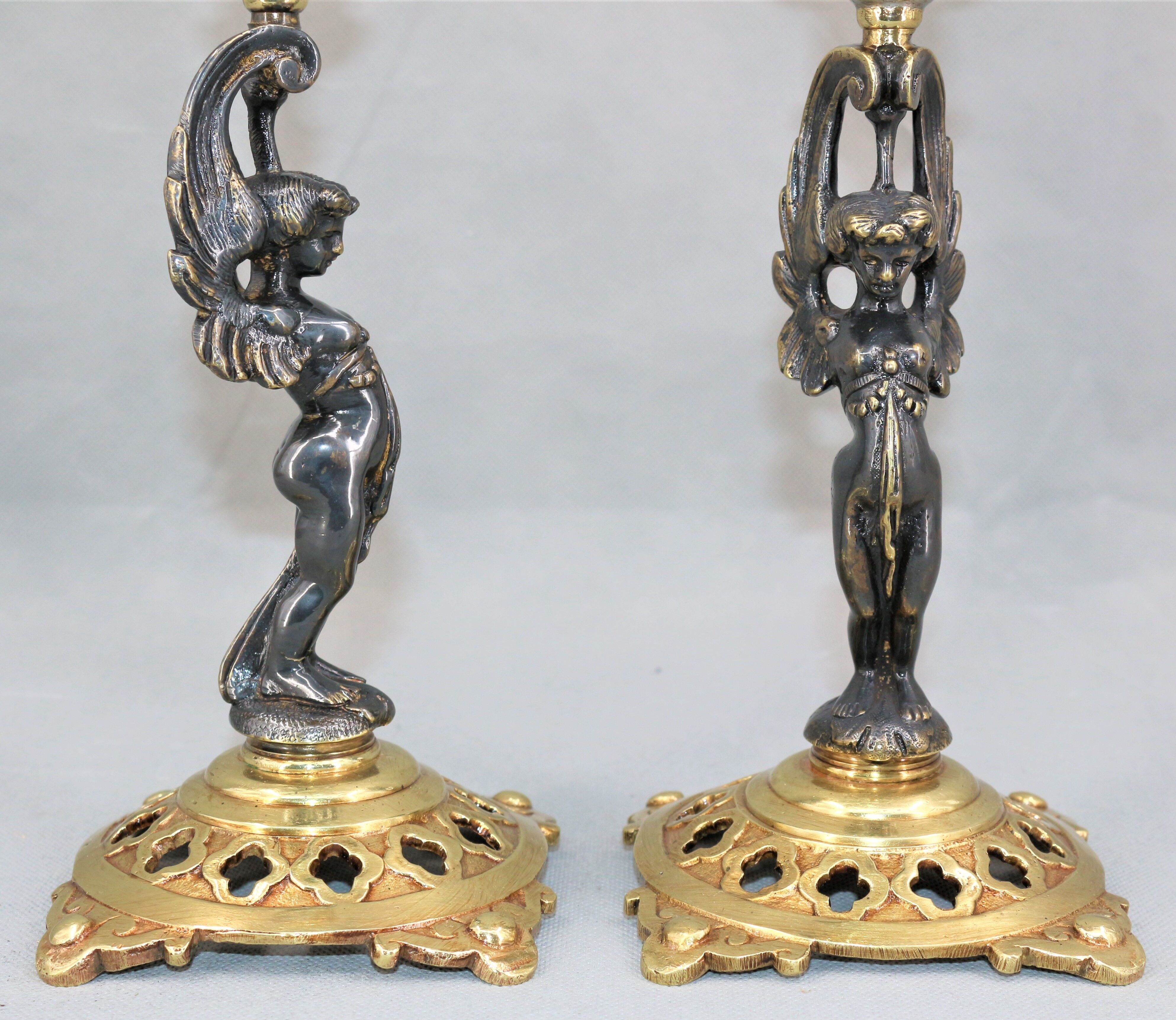 Pair of candle holders in gilded bronze and patinated with a candle